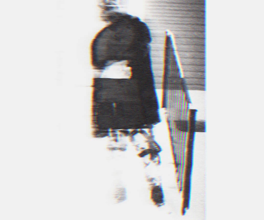 Alpha The Wolf standing in a long coat near a railing, shot from the side in a vertical crop, the figure and surroundings heavily smeared with horizontal scan-line ghosting