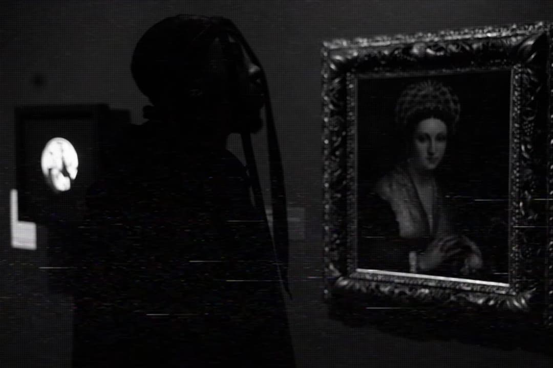 Alpha The Wolf silhouetted in profile inside a dark museum gallery beside a large ornate-framed oil portrait of a woman — datamoshed atmospheric glitch