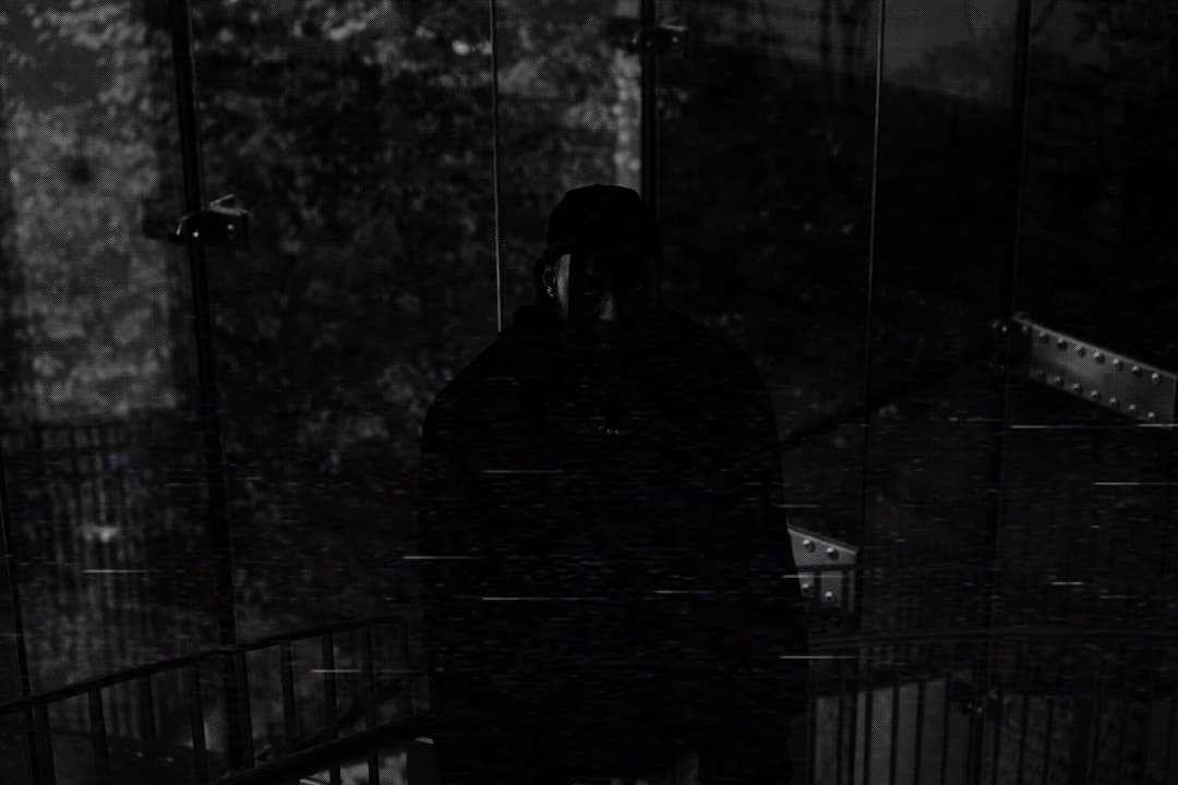 Alpha The Wolf nearly fully consumed by shadow inside the glass stairwell, only the faint outline of frame and chain visible — heavy datamosh scan-line distortion