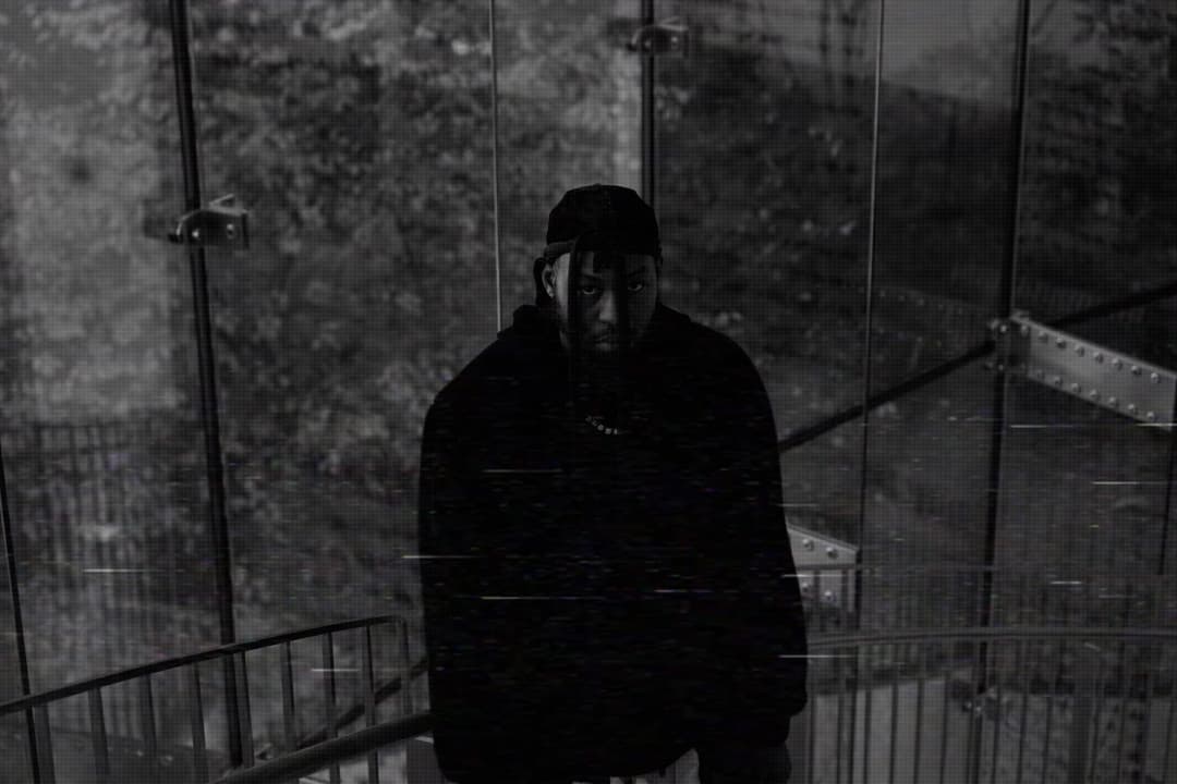 Alpha The Wolf facing the camera in the glass stairwell, slightly more exposed than 009, chain necklace and structure visible — datamosh scan-line glitch