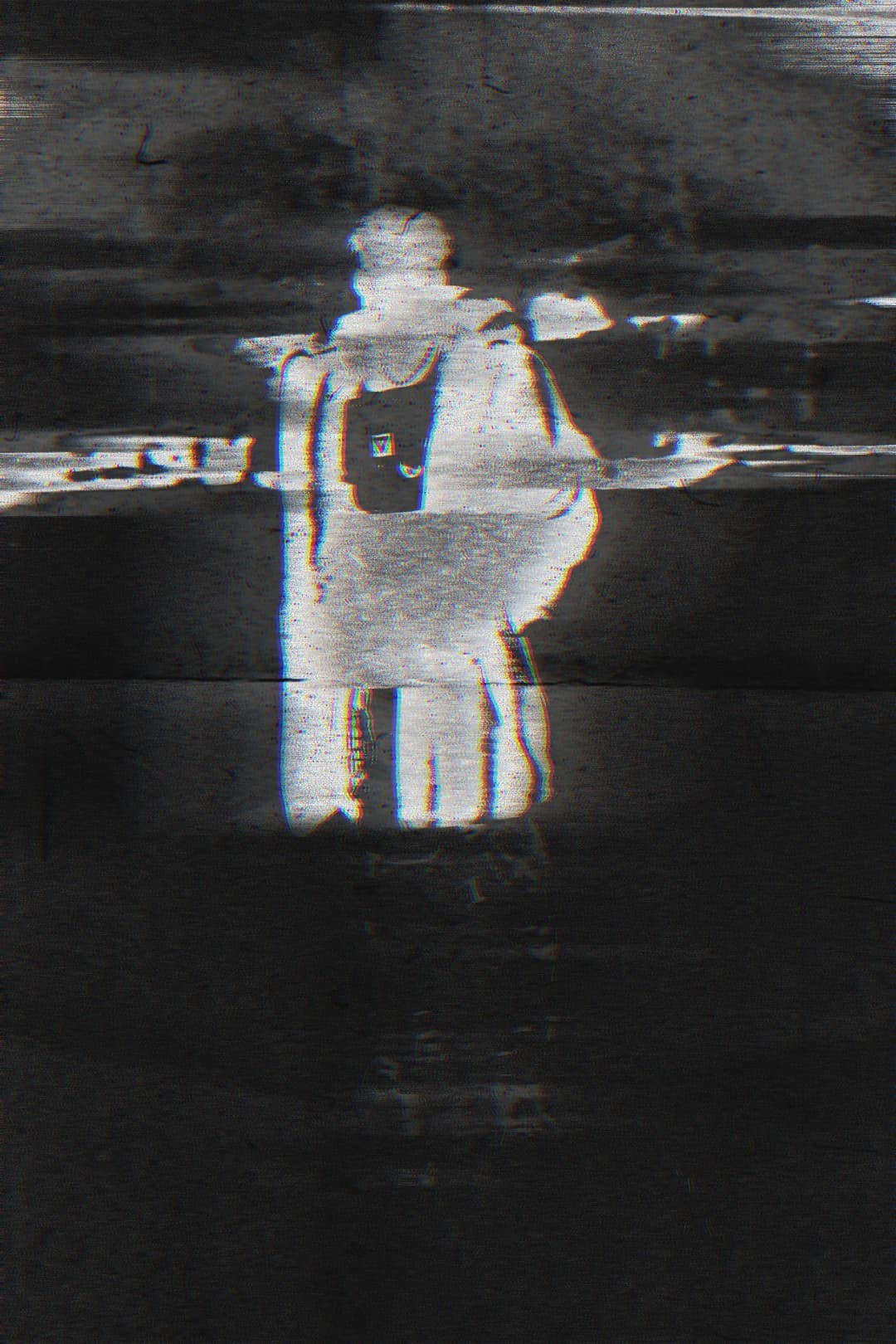 Alpha The Wolf standing with back to camera in near-total darkness, the silhouette glowing white at the center from a heavy scan-line and light-bleed effect