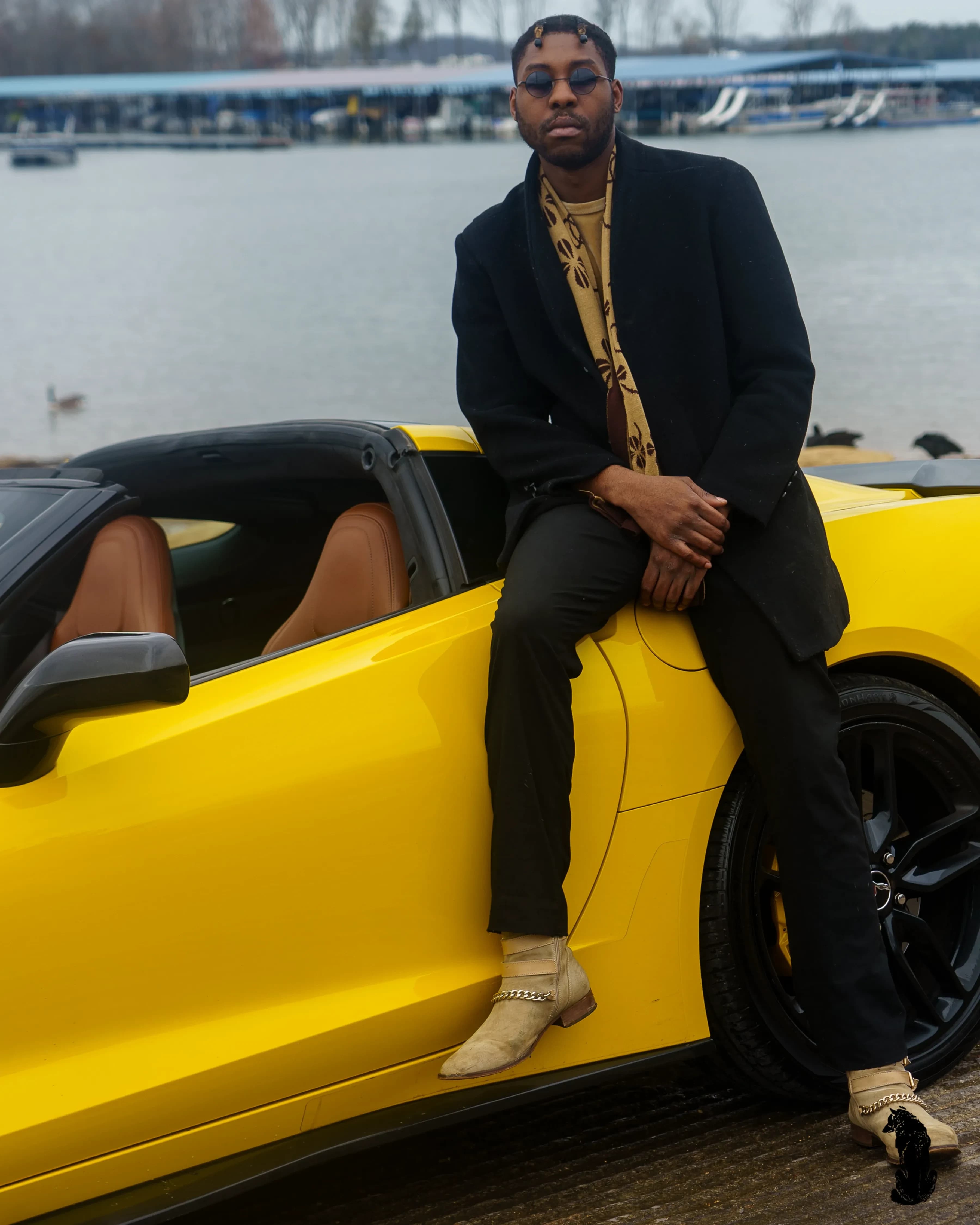 Alpha The Wolf Idles a Yellow Corvette at a Grey-Sky Boat Ramp for "Coupes by the Lakeside"