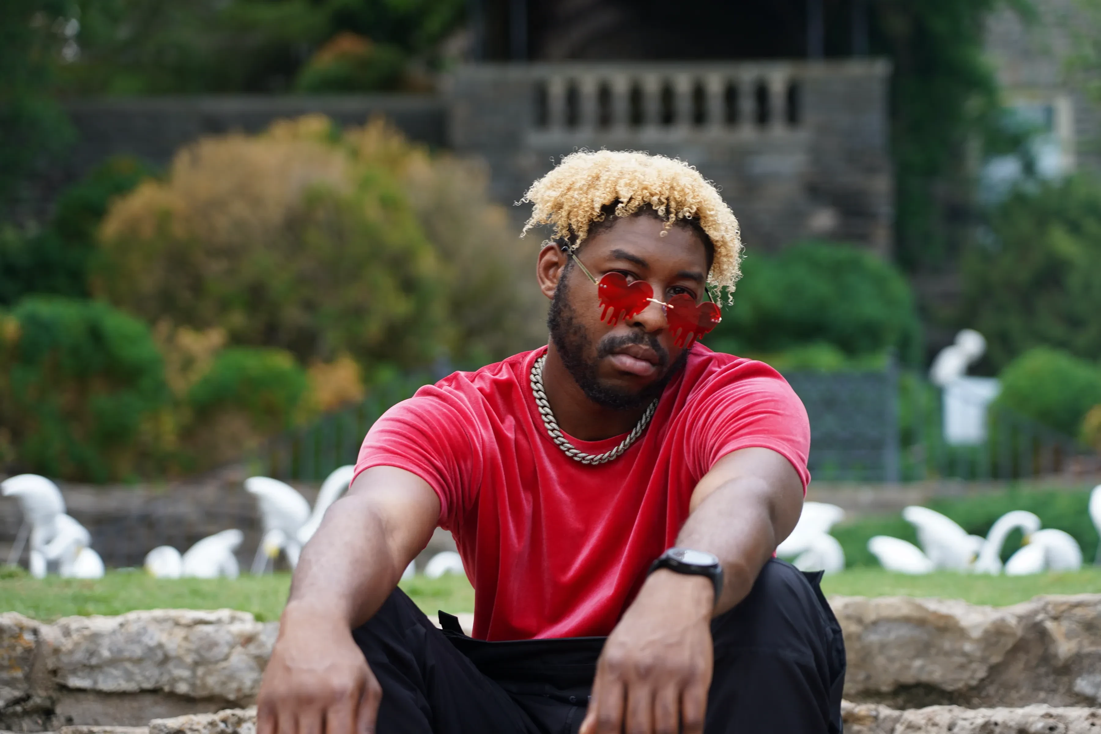 Alpha The Wolf Dons Red Heart Lenses Among Stone Urns for "Seeing Red"